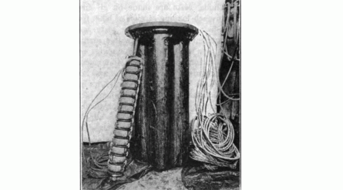 Contenitore per posizionare bobine Pupin. 14 bobine sono state messe su un fuso (appoggiato al corpo), sette fusi sono stati inseriti in un corpo pieno d'olio posto su uno dei pali della linea ogni 6000 piedi (1800 m)
